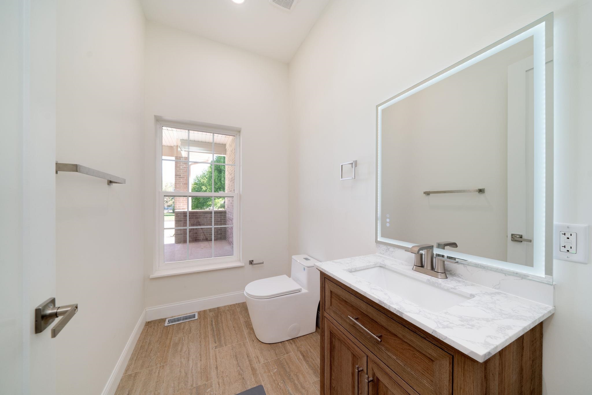 5145 Sycamore Ridge Road Belvidere, IL 61008 - Photo 35 of 57 a bathroom with a granite countertop sink a toilet a mirror and a window