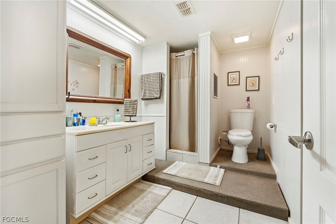 2724 3rd Street Southwest Lehigh Acres, FL 33976 - Photo 12 of 26 a spacious bathroom with a double vanity sink a mirror and a toilet