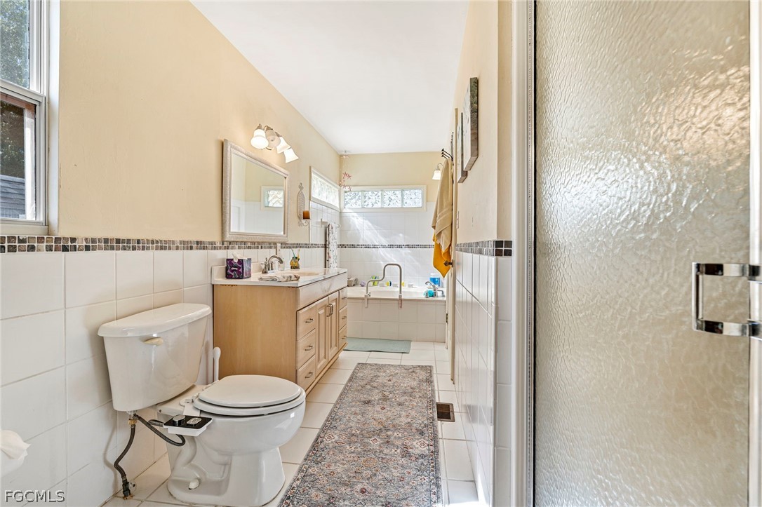 2724 3rd Street Southwest Lehigh Acres, FL 33976 - Photo 13 of 26 a bathroom with a toilet a sink and a mirror