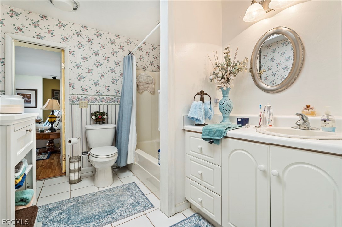 2724 3rd Street Southwest Lehigh Acres, FL 33976 - Photo 14 of 26 a bathroom with a toilet a sink and a mirror