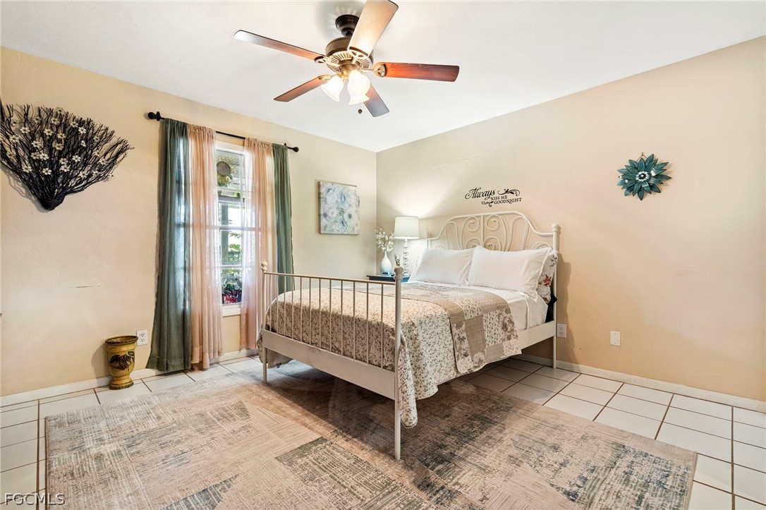 2724 3rd Street Southwest Lehigh Acres, FL 33976 - Photo 19 of 26 a bedroom with a bed and a chandelier