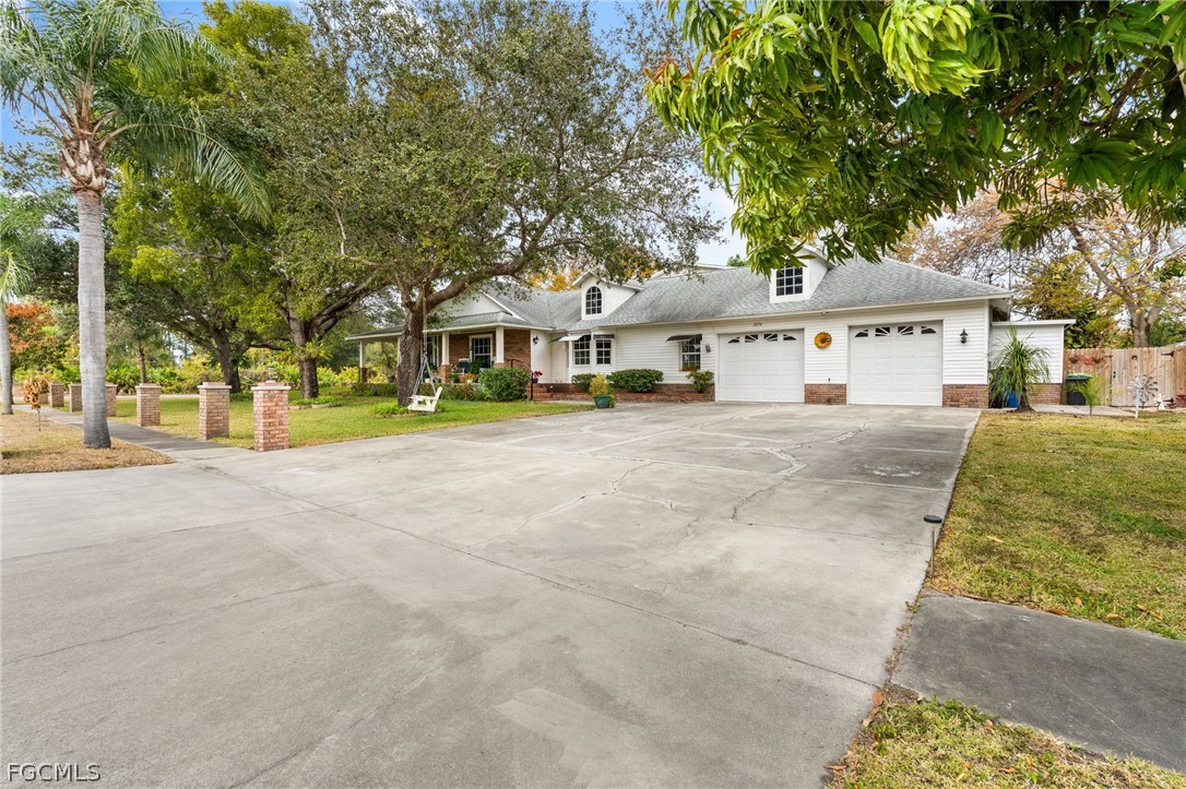 2724 3rd Street Southwest Lehigh Acres, FL 33976 - Photo 2 of 26 a view of house with outdoor space and tree s