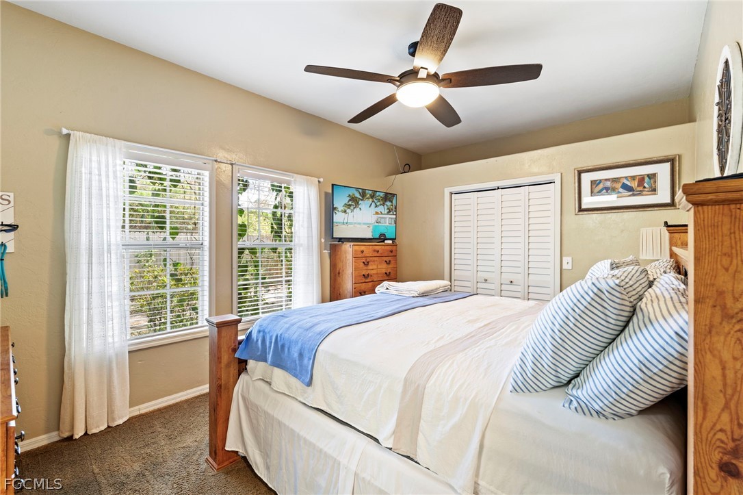 2724 3rd Street Southwest Lehigh Acres, FL 33976 - Photo 21 of 26 a bedroom with a large bed couch and a window