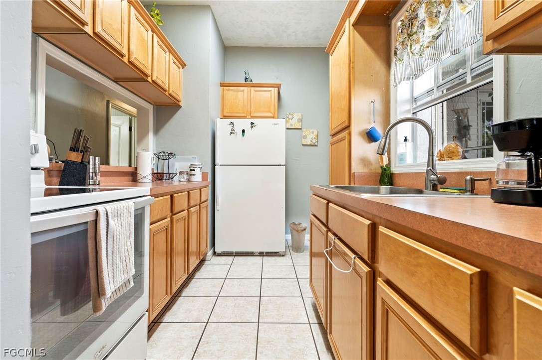 2724 3rd Street Southwest Lehigh Acres, FL 33976 - Photo 8 of 26 a kitchen with stainless steel appliances granite countertop a refrigerator and a stove top oven