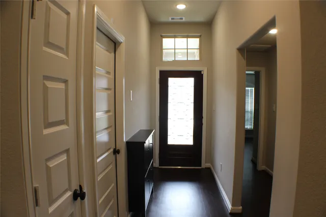 a view of a hallway with wooden floor and windows