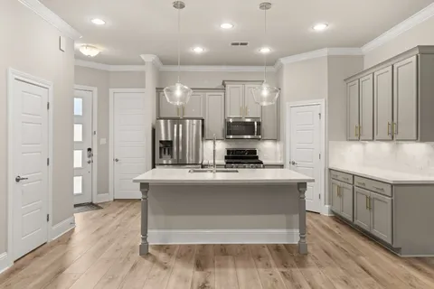 a view of kitchen with stainless steel appliances granite countertop a stove top oven and refrigerator