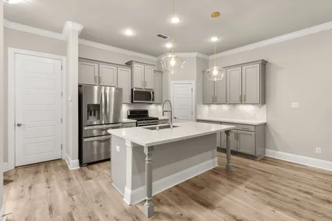 a kitchen with kitchen island a sink appliances and cabinets