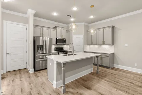 a kitchen with kitchen island a sink appliances and cabinets