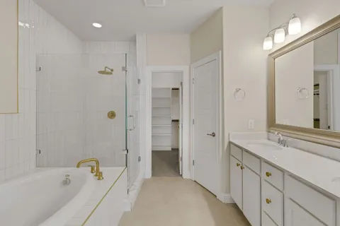 a bathroom with a tub sink shower and mirror