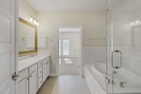 a bathroom with a tub a sink and a mirror