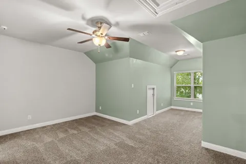 a view of an empty room with window and chandelier fan