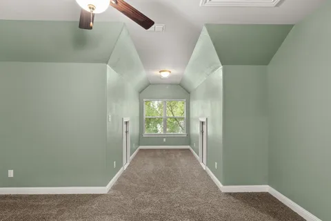 an entryway of a house with wooden floor windows and a ceiling fan