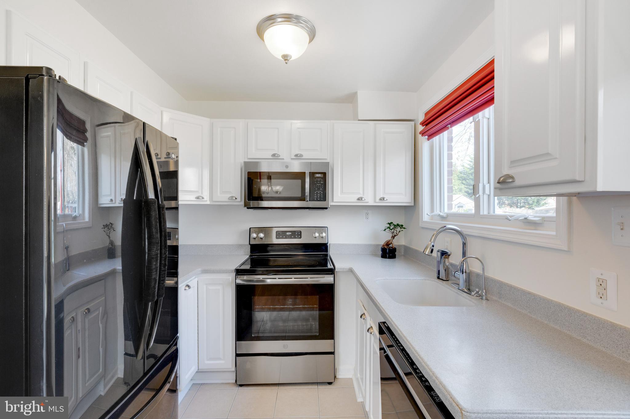 3903 Gannon Road Silver Spring, MD 20902 - Photo 13 of 51 a kitchen with stainless steel appliances cabinets a sink and a window