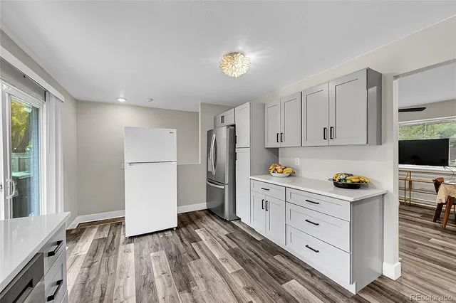 a kitchen with granite countertop a refrigerator and a stove top oven