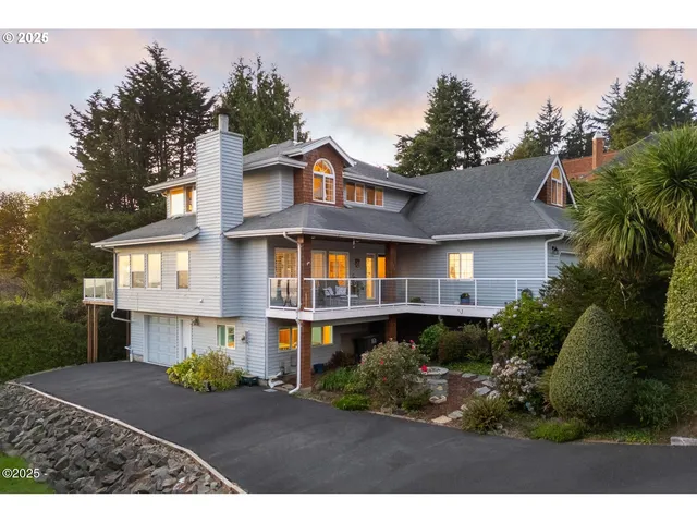 a front view of a house with a yard and trees