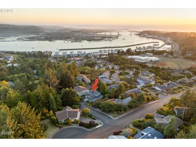 an aerial view of ocean and residential houses with outdoor space