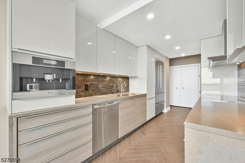 a open kitchen with white cabinets and stainless steel appliances