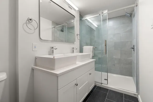 a bathroom with a sink toilet a mirror and shower