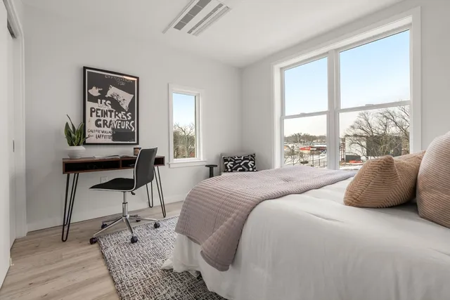 a bedroom with a bed and a large window