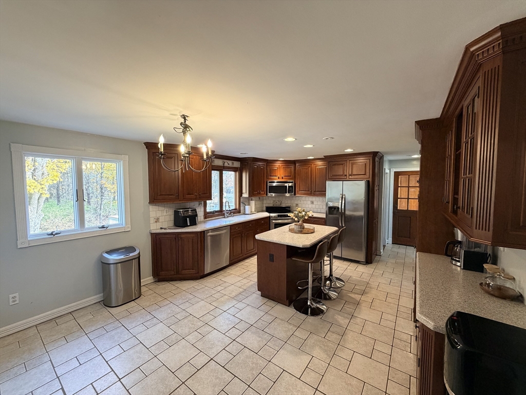 361 South Main Street Bellingham, MA 02019 - Photo 9 of 28 a kitchen with a sink dining table and chairs