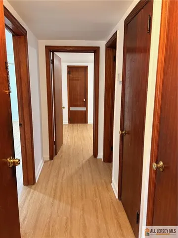 a view of a hallway with wooden floor and entryway