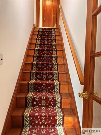 a view of a hallway with wooden floor and entryway