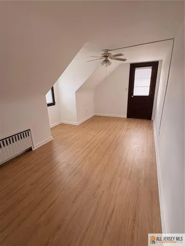 a view of a room with wooden floor staircase and a hallway