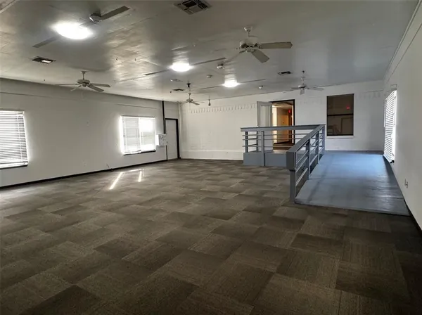 a view of a hall with table and chairs