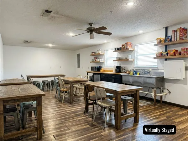 a kitchen with a table chairs and a wooden floor