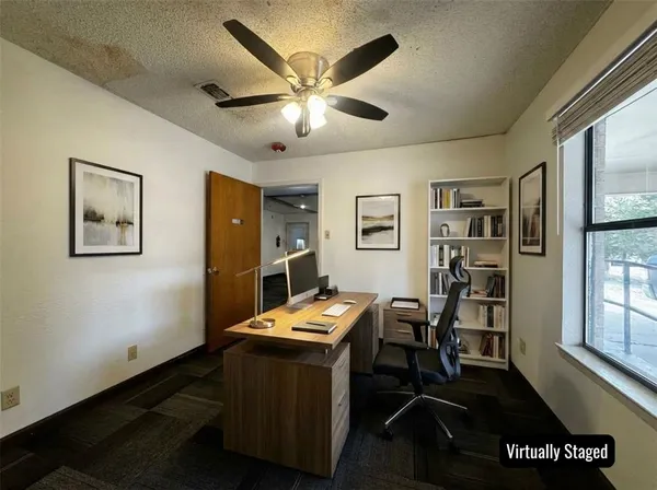 a view of a workspace with furniture and a window