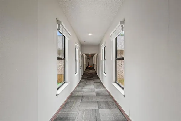 a view of a hallway with wooden floor