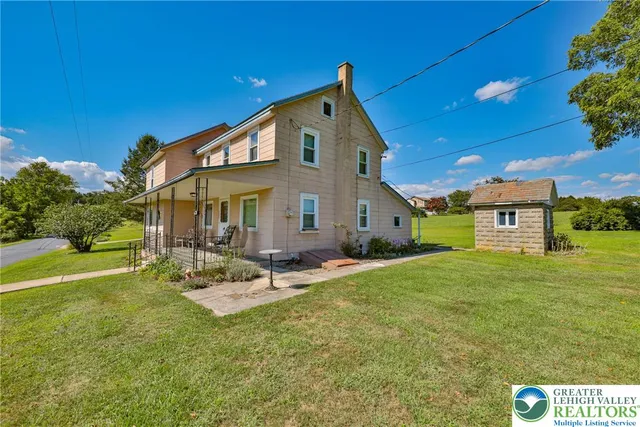 a view of a house with backyard and sitting area