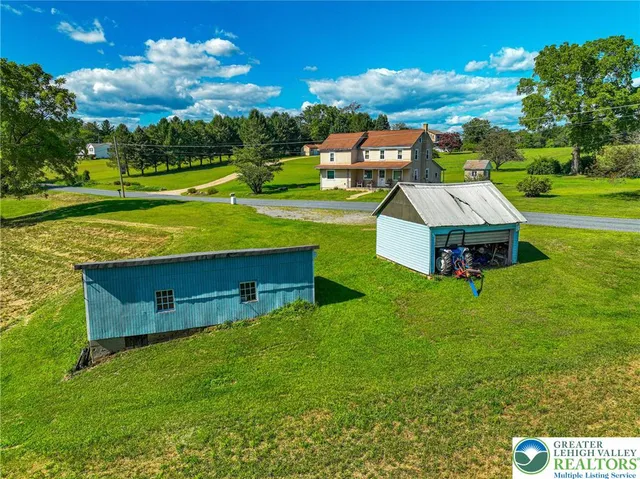an aerial view of a house with a garden and outdoor seating