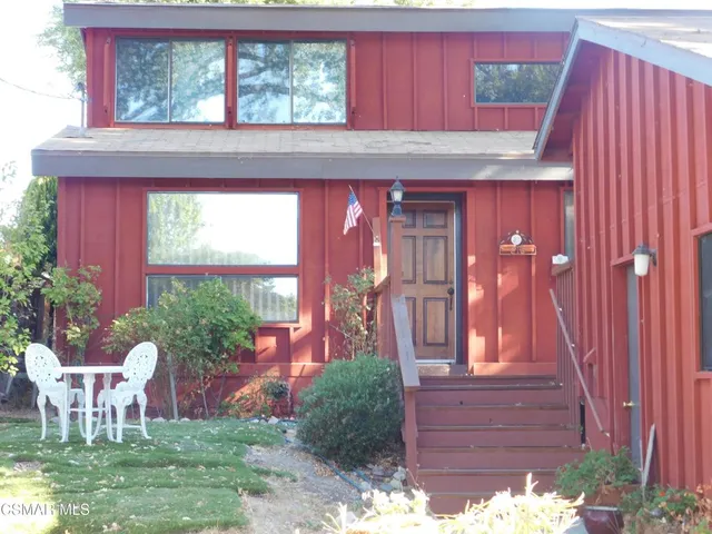 a front view of a house with a yard fountain and outdoor seating
