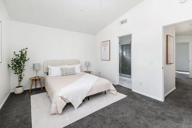 a bedroom with a bed and painting on the wall