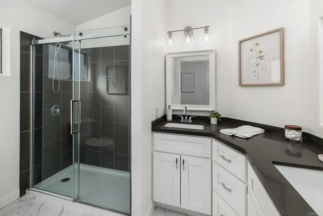 a bathroom with double vanity sinks and a mirror