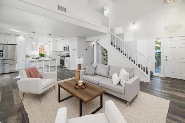 a living room with furniture and a dining table with wooden floor