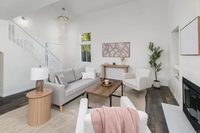 a living room with furniture a fireplace and a potted plant
