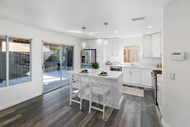 a large white kitchen with a table and chairs in it