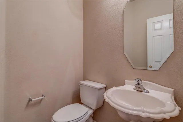 a white toilet sitting next to a bathroom sink