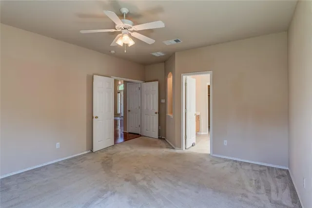 an empty room with a ceiling fan and a window