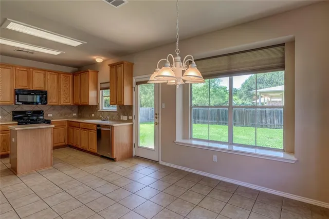 a kitchen with kitchen island granite countertop a stove a sink and a refrigerator