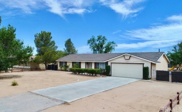 22351 Broken Lance Road Apple Valley, CA 92307 - Photo 1 of 1 a front view of a house with a yard and trees