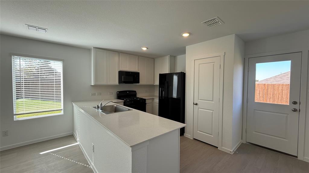 7701 Rutherford Lane McKinney, TX 75069 - Photo 5 of 20 a kitchen that has a refrigerator a sink and a stove in it