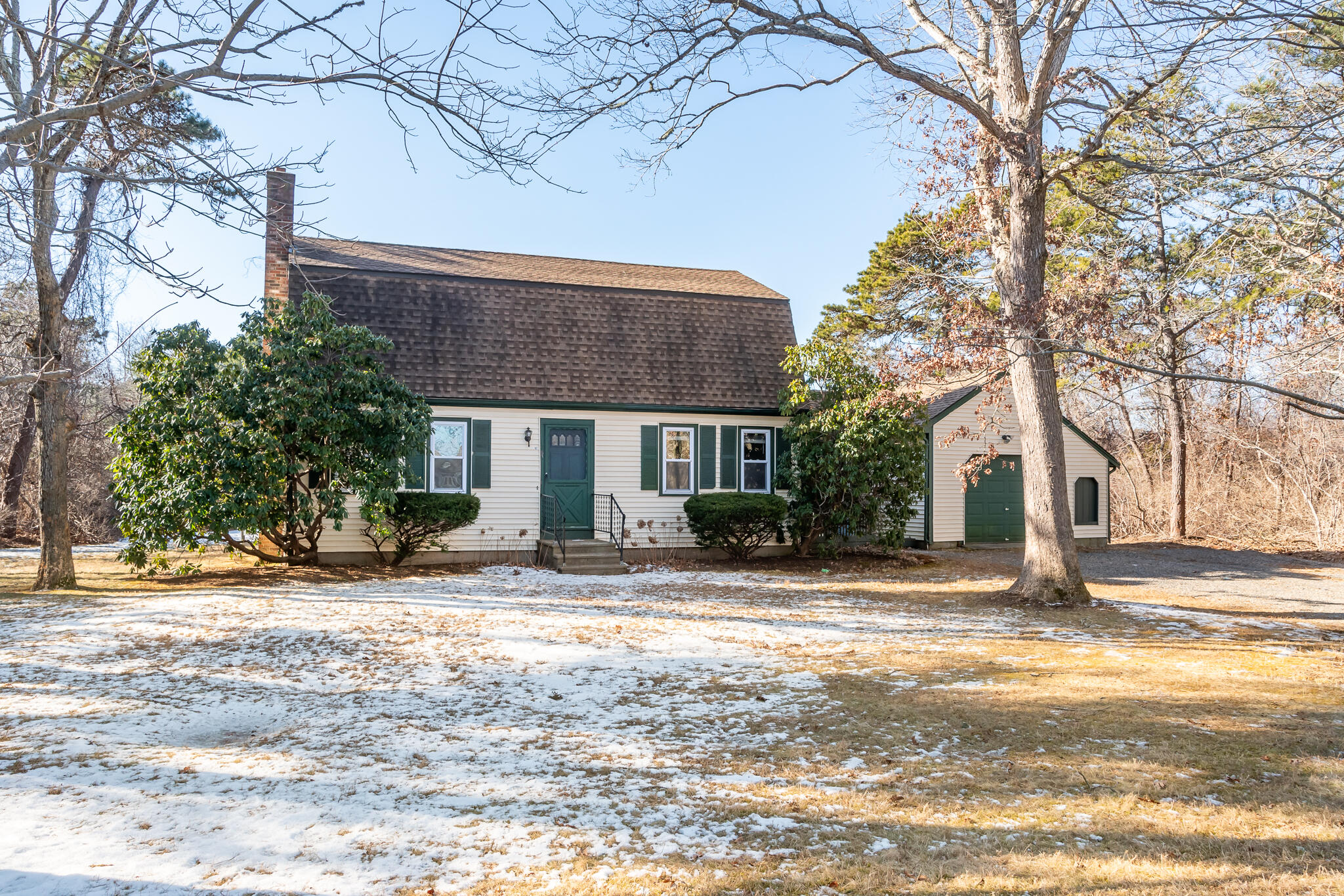 a view of a house with a yard covered with snow in the roadside