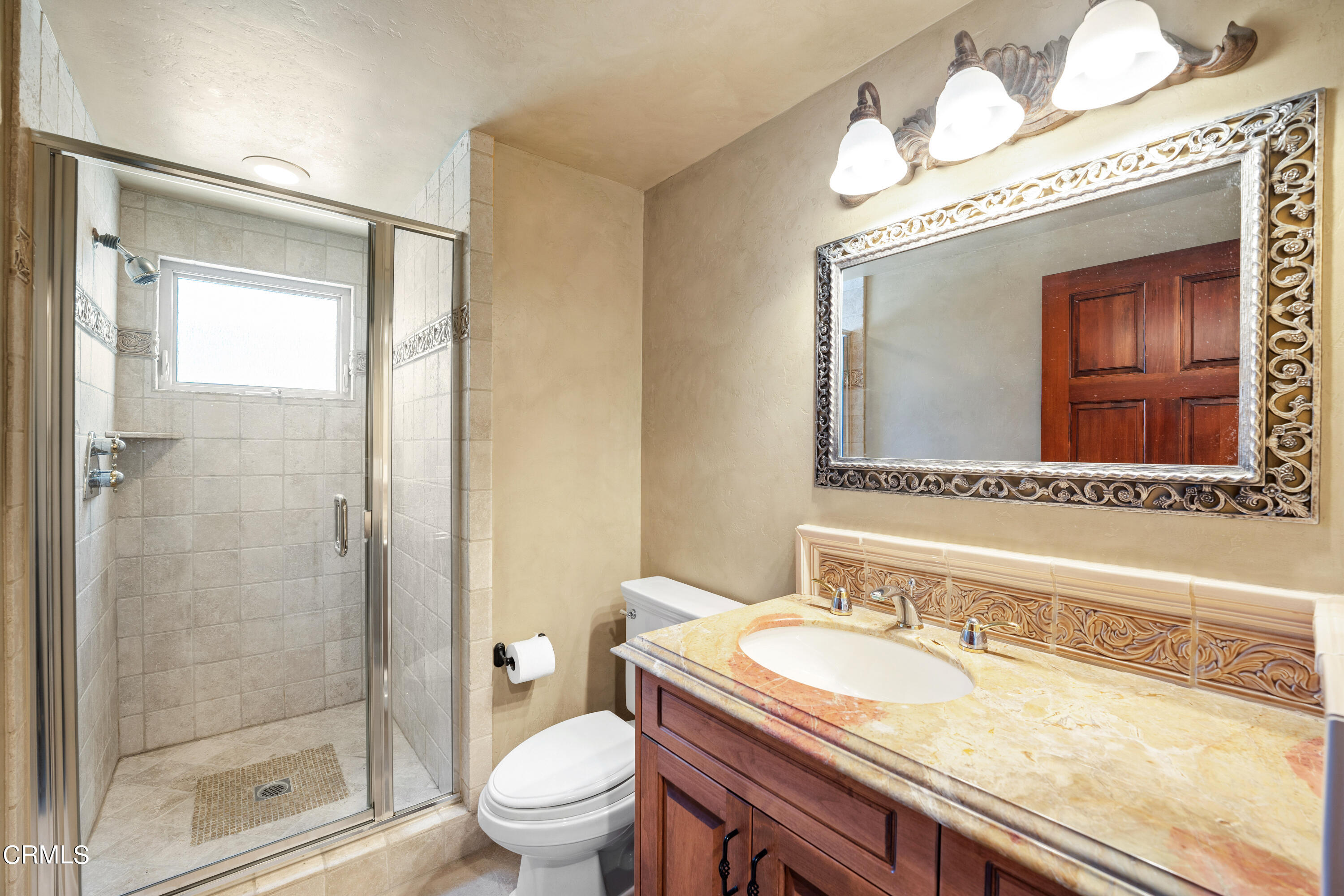 209 Ocean Drive Oxnard, CA 93035 - Photo 37 of 49 a bathroom with a granite countertop toilet a sink and a mirror