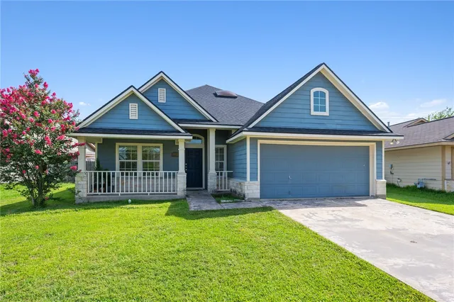 a front view of a house with a garden and yard