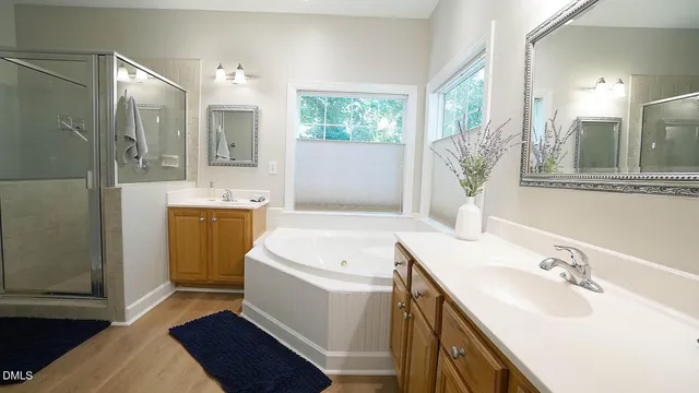 a bathroom with a double vanity sink a toilet a mirror and shower