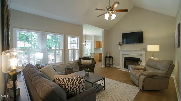a living room with furniture a fireplace and a flat screen tv