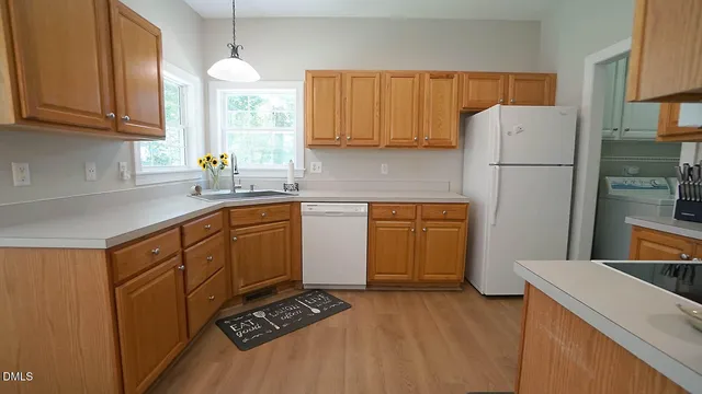 a kitchen with a sink a stove a refrigerator and cabinets